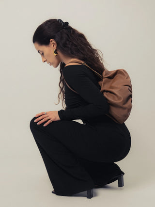 Modelo sentada con el bolso Carmen camel al hombro en estudio. Valentina Rivera Madrid.