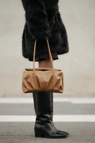 Mujer llevando bolso Leonor Camel lateral uso diario — Valentina Rivera Madrid