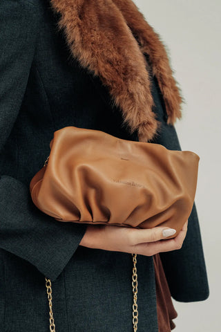 Modelo con el bolso Mini Carmen camel en la mano en estudio. Valentina Rivera Madrid.